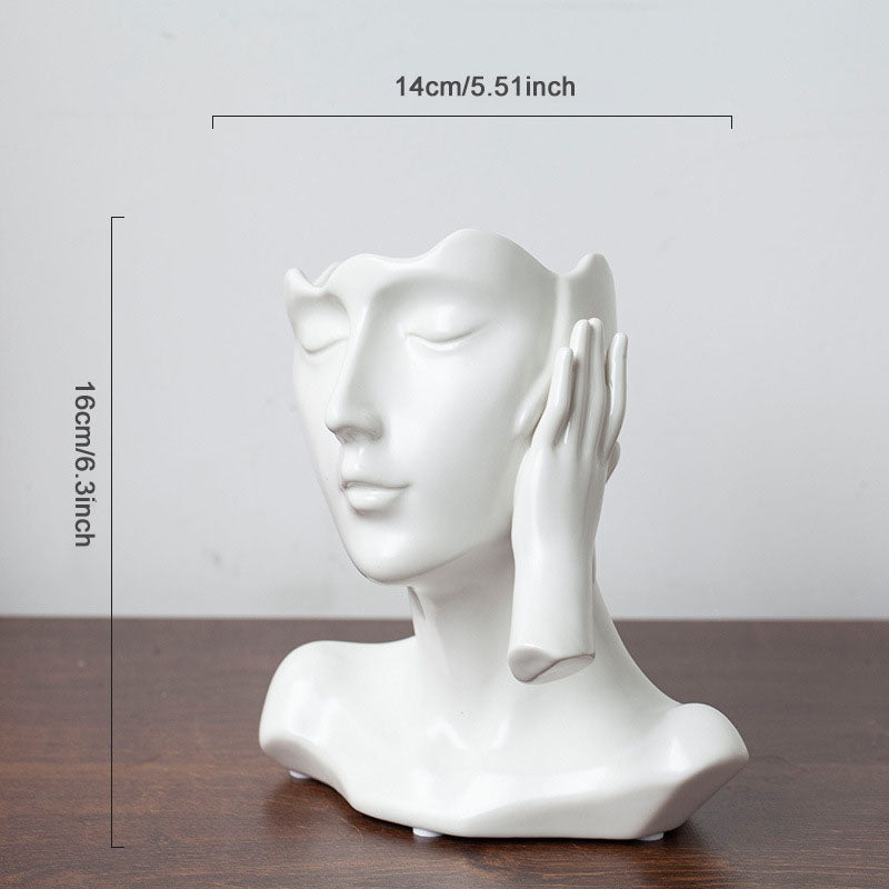 White ceramic bust sculpture on a wooden surface with dimensions indicated.
