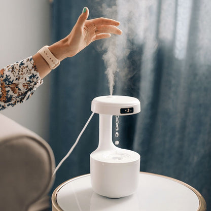 White humidifier emitting mist on a table with a blurred background
