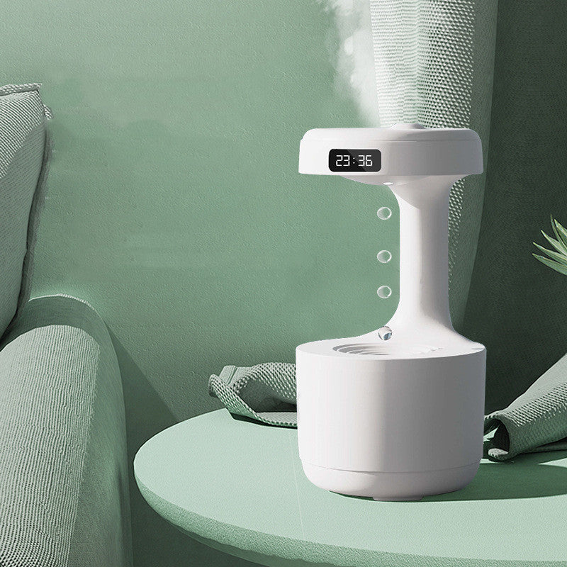 White humidifier with digital display on a green surface, surrounded by greenery.